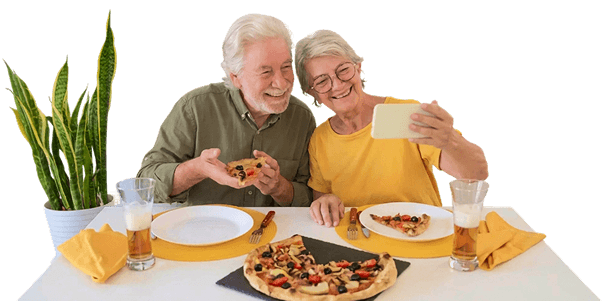 Smiling Elderly Couple Taking a Selfie Over Pizza at an Independent Living Facility
