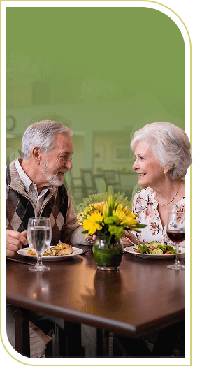 Elderly Couple Sharing a Romantic Dinner With Fresh Flowers in Independent Living