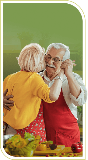 Elderly Couple in Aprons Dancing Together in the Kitchen in Independent Living