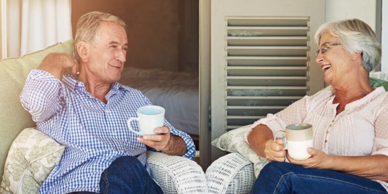 Elderly Couple Sharing Coffee on Porch at Independent Living Facility