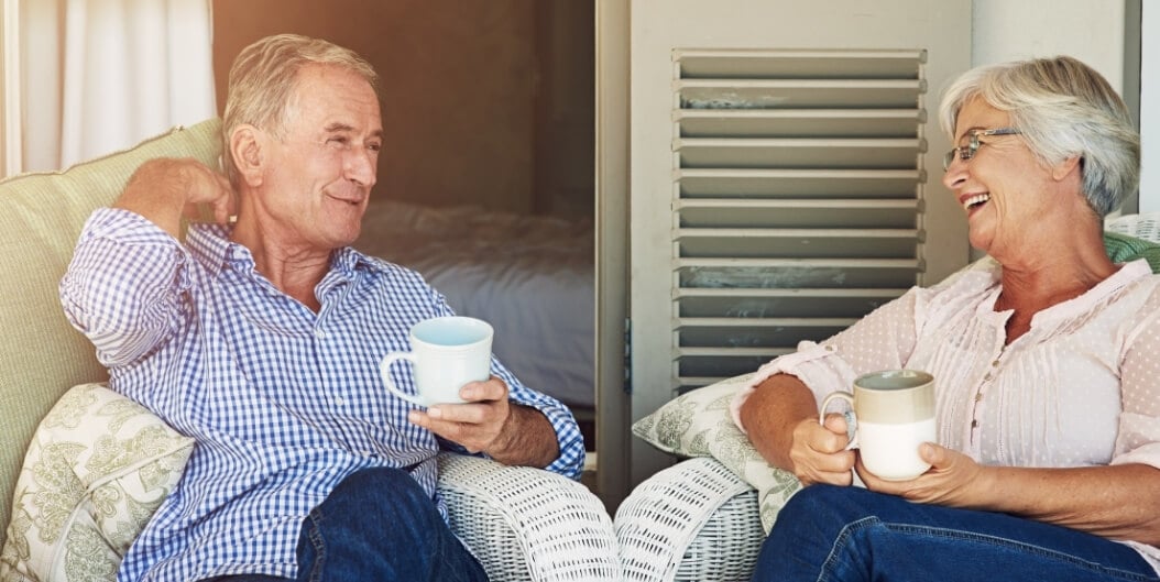 Elderly Couple Sharing Coffee on Porch at Independent Living Facility