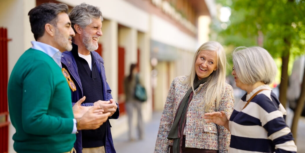 Elderly Friends Chatting Outdoors during Independent Living Facility Tour